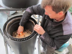 Stephan Gutzwiller starts the charring process in the prototype of his pyrolysis plant for agriculture. (Photo: Kaskad-E)